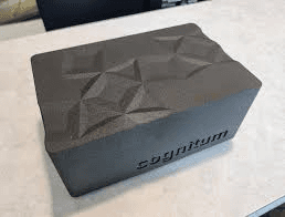 Cognitum One Seed — next-gen — top-down view of a matte-black enclosure with a faceted geometric top surface and the 'cognitum' wordmark on the front face.
